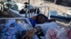 Una mujer en una camilla es fotografiada junto a un bebé después del terremoto de magnitud 7,2 en Les Cayes.