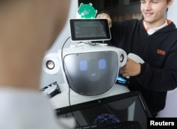 High school students Konstantinos Timinis and Vladimir Baranov work on "Alnstein", a robot powered by ChatGPT, in Pascal school in Nicosia, Cyprus on March 30, 2023. (REUTERS/Yiannis Kourtoglou)