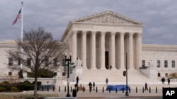 The Supreme Court is seen on Nov. 30, 2021, as activists arrive ahead of arguments on abortion at the court on Capitol Hill in Washington. 