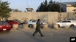 An Afghan security official patrols after an attack on the American University of Afghanistan in Kabul, Afghanistan, Aug. 25, 2016.