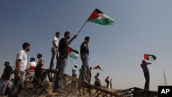 Palestinians hold Palestinian flags during a demonstration near the border between Gaza and Israel (file photo)