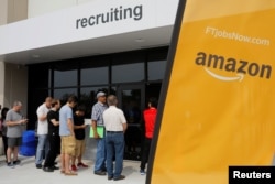 Job seekers line up to apply during "Amazon Jobs Day," a job fair being held at 10 fulfillment centers across the United States aimed at filling more than 50,000 jobs, at the Amazon.com Fulfillment Center in Fall River, Massachusetts, Aug. 2, 2017.