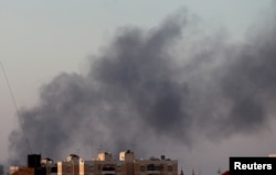 FILE - Black smoke marks where clashes are taking place between pro-government forces and an alliance of former anti-Gadhafi rebels, who have joined forces with the Islamist group Ansar al-Sharia in Benghazi, Libya, Aug. 15, 2015.