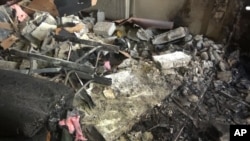 This photo released by the Syrian official news agency SANA shows damage after a suicide car bomber struck a police station in Damascus, Syria, Oct. 2, 2017. 