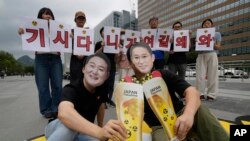 South Korean environmental activists wearing masks of Japanese Prime Minister Fumio Kishida, right, and South Korean President Yoon Suk Yeol rally against Kishida's planned visit, in Seoul, South Korea, , Sept. 5, 2024. The banner reads "Kishida why are you here."