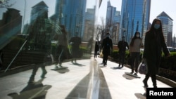 2020年4月2日北京商务区高峰时段人们戴着口罩上班。