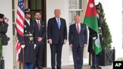 སྲིད་འཛིན་ཊམ་གྱིས་ཕོ་བྲང་དཀར་པོ་ནས་འཇོར་ཌན་གྱི་རྒྱལ་པོ་ལ་སྣེ་ལེན་གནང་བཞིན་པ།