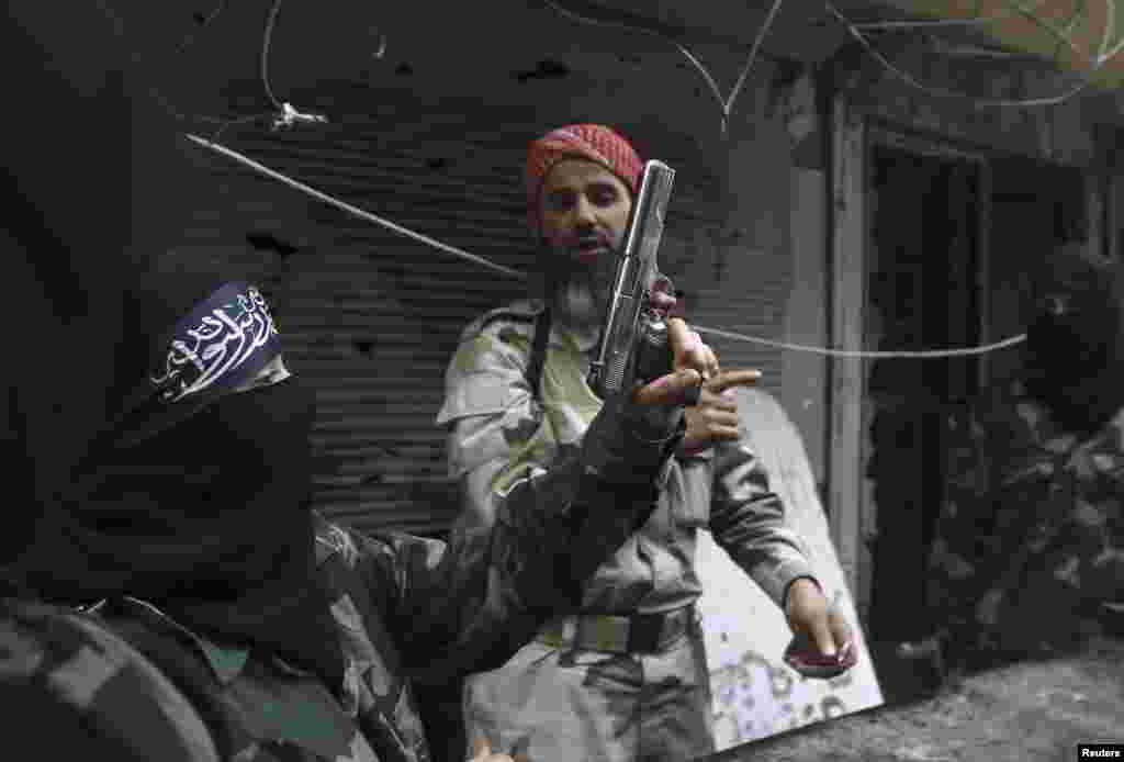 A female member of the Ahbab Al-Mustafa Battalion holds a gun as she undergoes military training in Aleppo's Salaheddine district, Syria, June 24, 2013. 