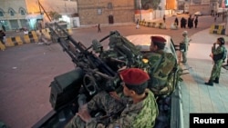 FILE - Houthi fighters in army uniforms patrol outside the presidential palace in Sana'a, Yemen, Feb. 6, 2015.