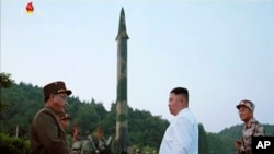 FILE - This image made from video of an undated still image broadcasted in a news bulletin on May 30, 2017, by North Korea's KRT shows North Korean leader Kim Jong Un and a missile launcher in North Korea. 