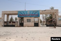 Empty shells line the ground as a Kurdish fighter from the People's Protection Units (YPG) walks toward al-Furat university in the Ghwairan neighborhood of Hasaka, Syria, Aug. 22, 2016.