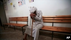 FILE - An elderly man waits to be treated for a suspected cholera infection at a hospital in Sana'a, Yemen, July 12, 2017.