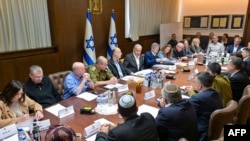  ইসরায়েলি সরকারের প্রেস দপ্তর থেকে দেওয়া এই ছবিতে দেখা যাচ্ছে প্রধানমন্ত্রী বেনিয়ামিন নেতোনিয়াহু ((বাম থেকে ষষ্ঠ) গাজায় অস্ত্রবিরতি ও পণবন্দিদের মুক্তির বিষয়ে চুক্তি সম্পর্কে ভোট পরিচালনার জন্য নিরাপত্তা বিষয়ক মন্ত্রী সভার এক বৈঠকে সভাপতিত্ব করছেন। 