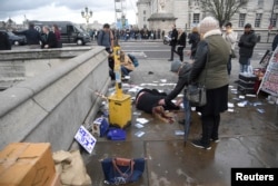 A woman lies injured after an incident on Westminster Bridge in London, March 22, 2017.