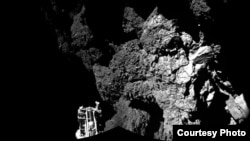 FILE - Rosetta’s lander Philae is safely on the surface of Comet 67P/Churyumov-Gerasimenko, as these first two CIVA images confirm. One of the lander’s three feet can be seen in the foreground. The image is a two-image mosaic, Nov. 13, 2014. (Courtesy: European Space Agency)