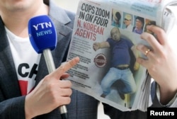FILE - A reporter holds up a local newspaper during his report in front of the morgue at Kuala Lumpur General Hospital where Kim Jong Nam's body is held for autopsy in Malaysia, Feb. 18, 2017.