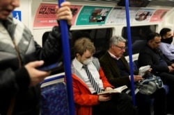 A man wearing a protective mask travels on a tube in London, March 11, 2020.