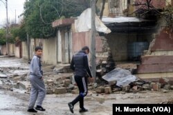 Outside this home, children play in the streets in eastern Mosul, Iraq, March 8, 2017, despite the smell of what they believe to be a homemade chemical Islamic State bomb that hit a nearby house.
