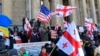 Demonstrators wave Georgian and American flags as they gather in Tbilisi, Georgia, Nov. 17, 2019. Hundreds of demonstrators gathered outside the parliament building to protest the failure of the legislature to pass promised election reform.