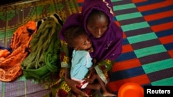 Bonko Diawara holds her 17-month-old daughter, Diarra Yattibere, as she recovers from malnutrition, at a nutrition center at Selibaby's hospital, in the Guidimakha region, Mauritania, June 2012.