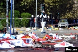 police forensic expert takes pictures as he examines the scene following explosions during a peace march in Ankara, Turkey, Oct. 10, 2015.
