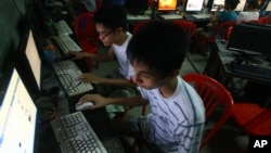 In this Sept. 27, 2012 photo, two Vietnamese students use Facebook at an internet cafe near their dormitory while they could not log in Facebook from their mobile phones because of firewall in Hanoi, Vietnam.