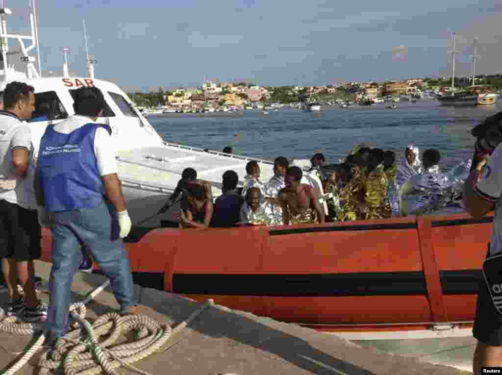 Rescued migrants arrive onboard a coast guard vessel at the harbor of Lampedusa, Italy, Oct. 3, 2013. (Nino Randazzo/ASP press office)
