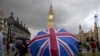 FILE - A pedestrian shelters from the rain beneath a Union Jack-themed umbrella near the Big Ben clock face and the Elizabeth Tower at the Houses of Parliament in central London, following the pro-Brexit result of the UK's EU referendum vote, June 25, 2016.