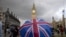 FILE - A pedestrian shelters from the rain beneath a Union Jack-themed umbrella near the Big Ben clock face and the Elizabeth Tower at the Houses of Parliament in central London, following the pro-Brexit result of the UK's EU referendum vote, June 25, 2016.