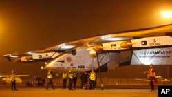 Crew members gather to push the Solar Impulse 2 towards a hangar after it landed at an airport in Ahmadabad, India, March 11, 2015.