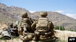 In this file photo taken on June 6, 2019 US soldiers look out over hillsides during a visit of the commander of US and NATO forces in Afghanistan General at the Afghan National Army (ANA) checkpoint in Nerkh district of Wardak province. 