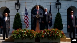 President Donald Trump delivers remarks about the economy on the South Lawn of the White House, July 27, 2018, in Washington. From left, Commerce Secretary Wilbur Ross, Trump, Vice President Mike Pence, and Treasury Secretary Steve Mnuchin.