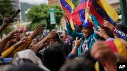 Una venezolana manifiesta durante la inscripción del candidato de Primero Justicia a la primaria opositora, Henrique Capriles Radonski, en Caracas, el 24 de junio de 2023.