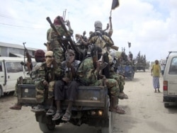FILE - Al-Shabab fighters display weapons as they conduct military exercises in northern Mogadishu, Somalia.