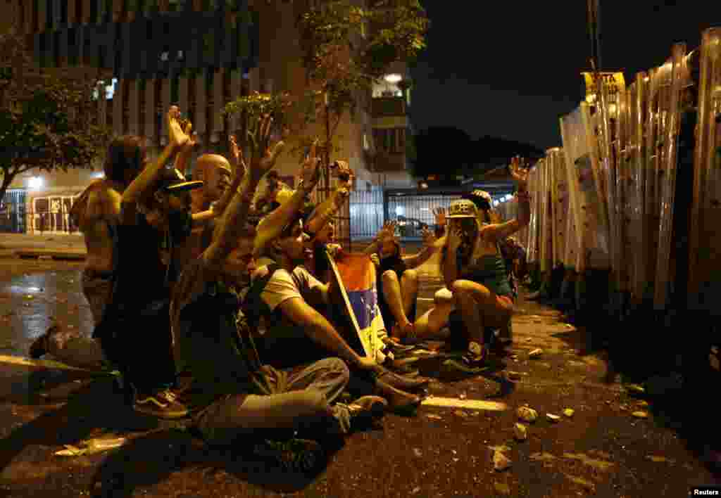 Supporters of opposition leader Henrique Capriles stand in front of riot police as they demonstrate for a recount of the votes in Sunday's election, in Caracas, April 15, 2013.