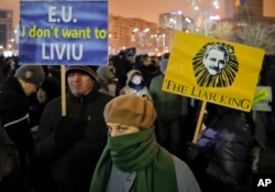 Demonstrators hold banners depicting the head of the ruling Social Democrat party Liviu Dragnea during an anti-government protest in Bucharest, Romania, Feb. 11, 2017.
