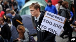 A protester holds a placard outside St Paul's Cathedral in the city of London on October 16, 2011 as part of a global day of protests.