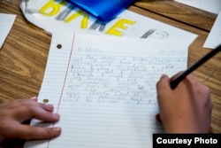 A student, Blake Mechels, writes a letter to student Elisa, of Dadaab Refugee Camp. Fifth graders at High Peaks Elementary School participate in a Letters of Hope project in Boulder, Colorado. (Carey Wagner/CARE)