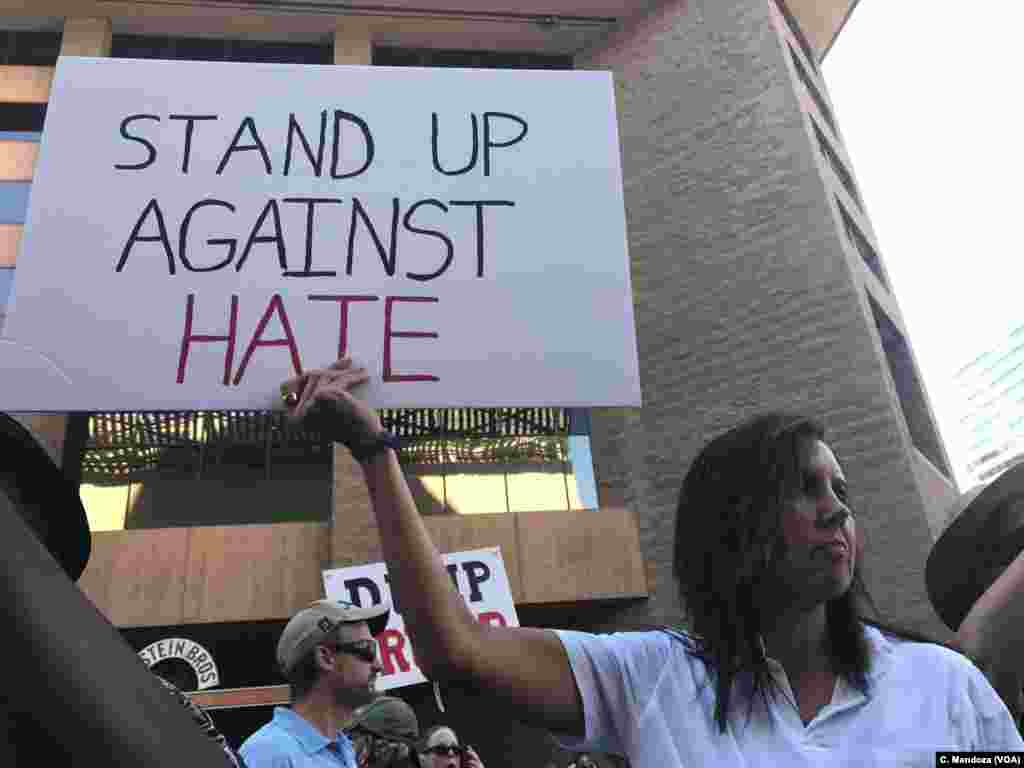 A woman protesting the campaign-style rally to be held by President Donald Trump holds a sign at the convention center in Phoenix, Aug. 22, 2017.