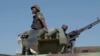 FILE - In this image made from video, a Mozambican soldier rides on an armored vehicle at the airport in Mocimboa da Praia, Cabo Delgado province, Mozambique, Aug. 9, 2021. The U.N. Office for the Coordination of Humanitarian Affairs is seeking $413 million to support the region.