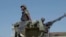 FILE - In this image made from video, a Mozambican soldier rides on an armored vehicle at the airport in Mocimboa da Praia, Cabo Delgado province, Aug. 9, 2021.