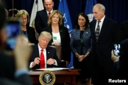 U.S. President Donald Trump signs an executive order at Homeland Security headquarters in Washington, D.C., Jan. 25, 2017.
