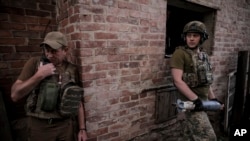 乌克兰军队第24机械化旅新闻处提供的照片显示,乌军士兵准备在顿涅茨克州某处前线向俄军发射120毫米迫击炮弹。(2024年6月4日)