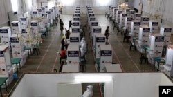 Health workers perform testing at a COVID-19 testing center at the Palacio de Manila during an enhanced community quarantine to prevent the spread of the new coronavirus on Monday, May 11, 2020. Several sports and events venues have been converted…