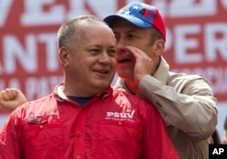 Government politician Diosdado Cabello listens to Venezuela's Vice President Tareck El Aissami at a rally opposing the United States and possible OAS sanctions, in Caracas, Venezuela, March 28, 2017.