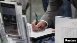 FILE - A veteran fills out a form at a military job fair in Sandy, Utah, U.S., March 26, 2019. 