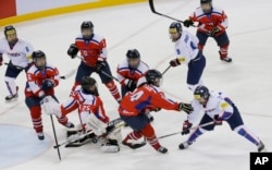 FILE - South Korea's Lee Eun-ji, bottom right, scores a goal as North Korea's Kim Kum Bok, bottom second right, tries to block the puck during their IIHF Ice Hockey Women's World Championship Division II Group A game in Gangneung, South Korea, April 6, 2017.