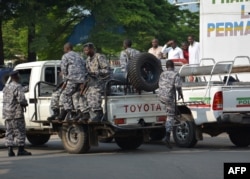 FILE - Burundi policemen patrol the street following a grenade attack in Bujumbura, Burundi. At least a dozen people were wounded on Feb. 15 when attackers on a motorbike hurled three grenades and various locations in the capital, the latest in a string of attacks.