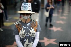 A woman who declined to give her name wears an outfit with the names of all the men in Hollywood she says sexually harassed her, during a protest march for survivors of sexual assault and their supporters in Hollywood, Los Angeles, California, Nov. 12, 2017.