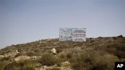 A sign advertising a planned housing project stands in the West Bank Jewish settlement of Ariel, 05 Oct 2010